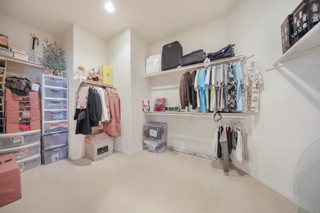 a view of walk in closet with clothes and shoes