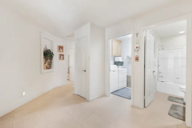 a view of a hallway with closet and bathroom