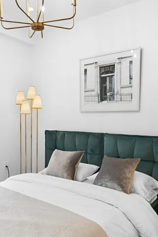 a bedroom with a bed and a painting on the wall