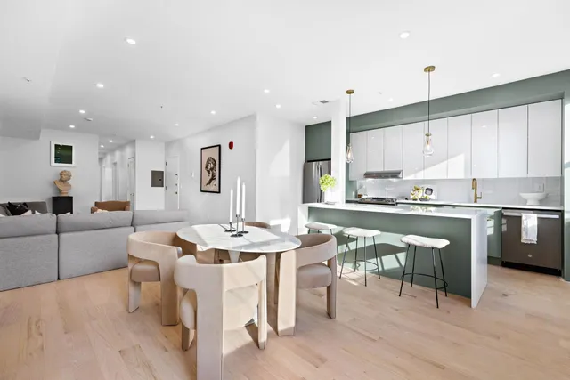 a large kitchen with kitchen island a island a stove a sink a dining table and chairs