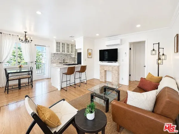 a living room with furniture a flat screen tv and kitchen view