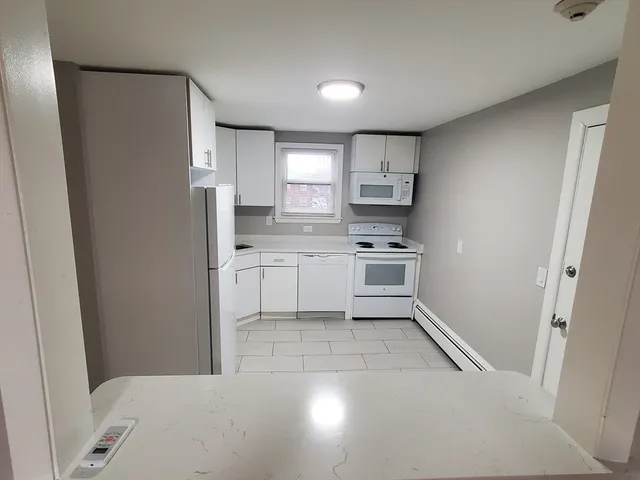 a kitchen with white cabinets and white appliances