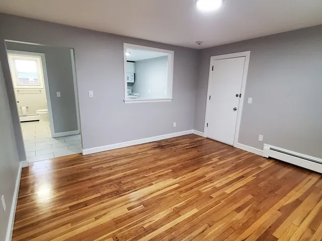 a view of empty room with wooden floor