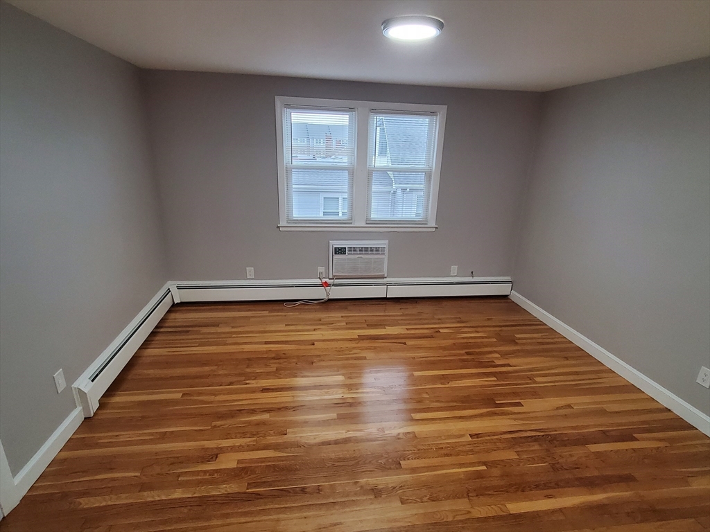 433 B Sea Street, Unit 5 Quincy, MA 02169 - Photo 4 of 14 a view of empty room with wooden floor and fan