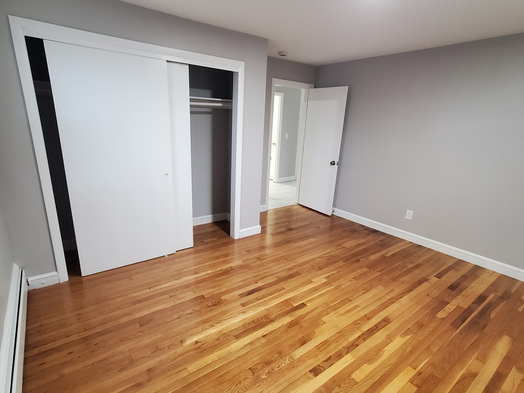 433 B Sea Street, Unit 5 Quincy, MA 02169 - Photo 6 of 14 a view of an empty room with wooden floor and a window