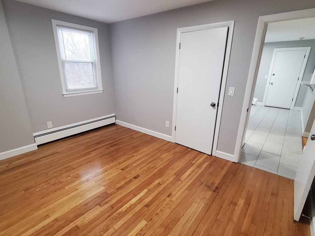 433 B Sea Street, Unit 5 Quincy, MA 02169 - Photo 8 of 14 an empty room with wooden floor and windows