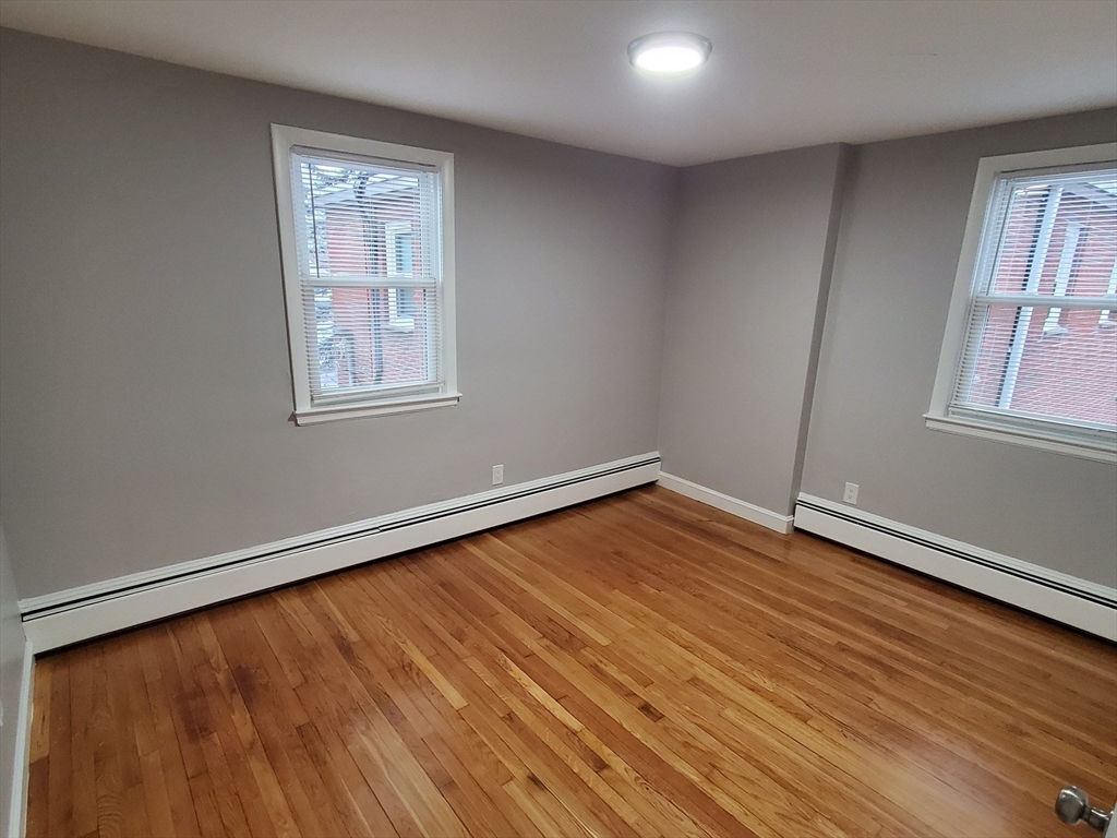433 B Sea Street, Unit 5 Quincy, MA 02169 - Photo 9 of 14 an empty room with wooden floor and windows