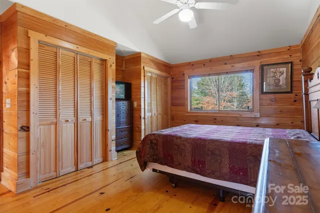 a bed sitting in a spacious bedroom next to a window