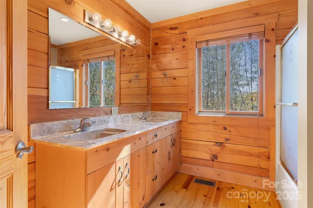 a bathroom with a granite countertop sink and a shower