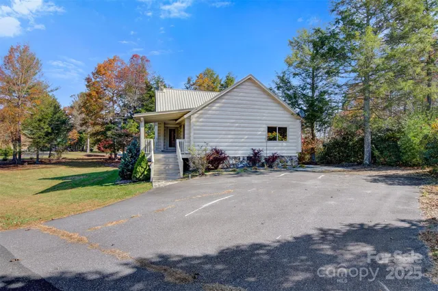 a view of a house with a yard and large trees