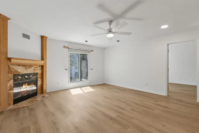 a view of an empty room with a fireplace and a window