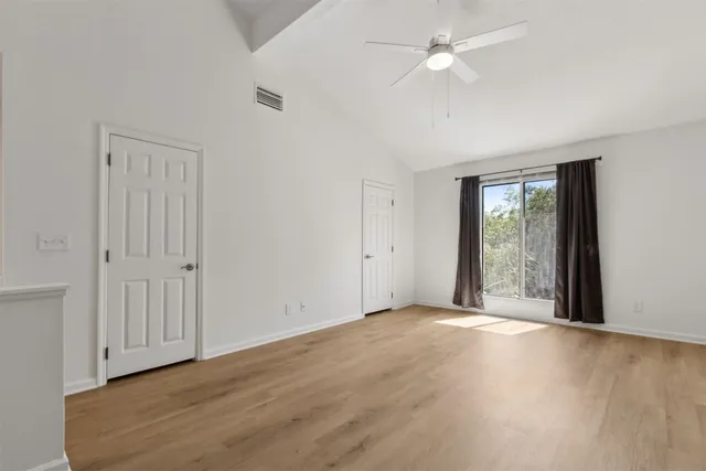 a view of an empty room with wooden floor