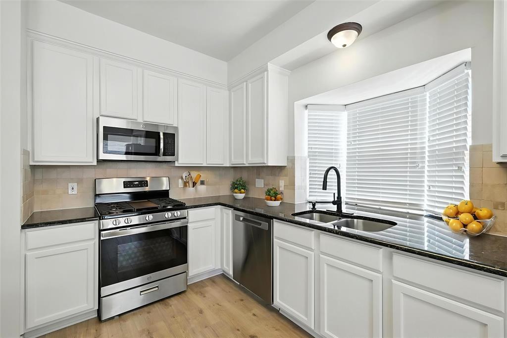 5713 Green Hollow Lane The Colony, TX 75056 - Photo 12 of 29 a kitchen with granite countertop a sink stainless steel appliances and cabinets
