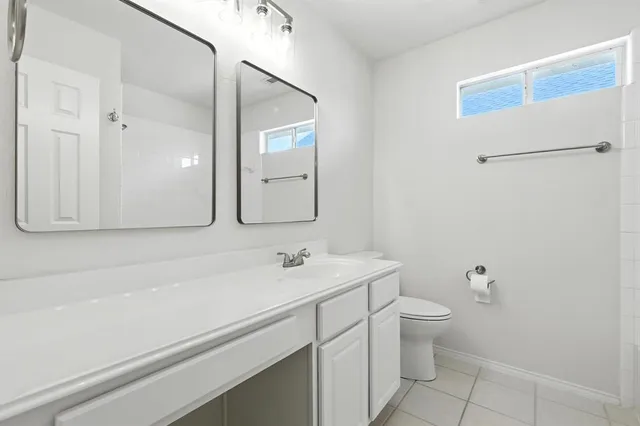 a bathroom with a sink a toilet and mirror
