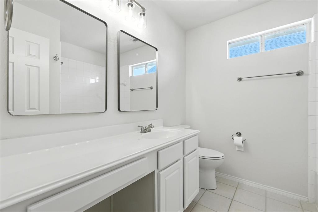 5713 Green Hollow Lane The Colony, TX 75056 - Photo 22 of 29 a bathroom with a sink a toilet and mirror