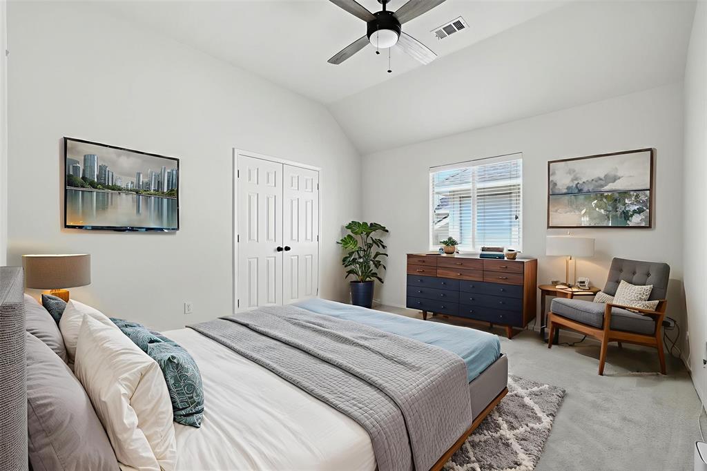 5713 Green Hollow Lane The Colony, TX 75056 - Photo 24 of 29 a bedroom with a large bed and a chandelier