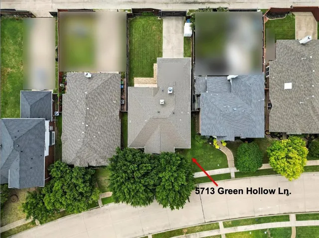 an aerial view of a house with a yard and lake view