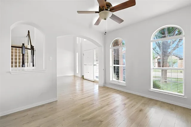 a view of a room with wooden floor chandelier and a window