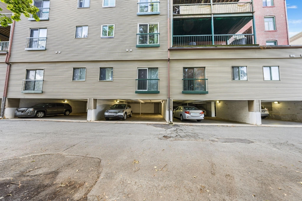 315 Rantoul Street, Unit 402 Beverly, MA 01915 - Photo 18 of 27 a front view of a house with a yard and parking space