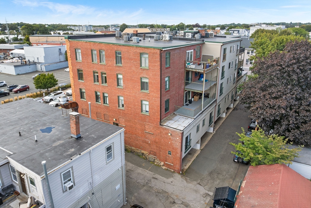 315 Rantoul Street, Unit 402 Beverly, MA 01915 - Photo 25 of 27 an aerial view of a house with a yard