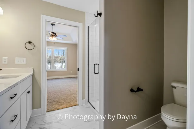 a bathroom with a granite countertop sink a toilet and a mirror