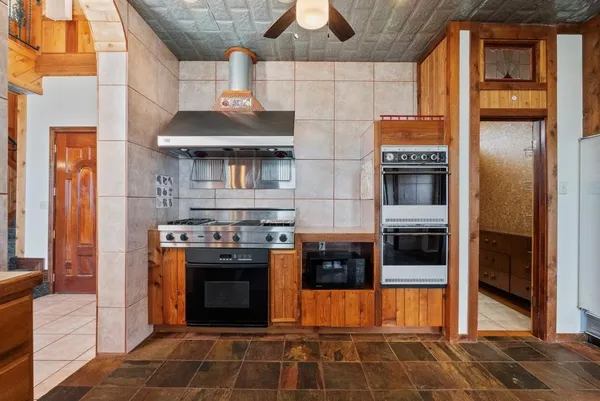 a large kitchen with stainless steel appliances kitchen island granite countertop a large counter top and outdoor space