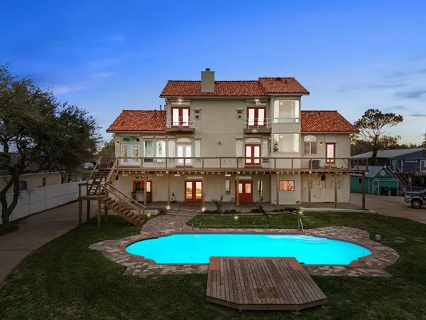 a view of a house with swimming pool and yard