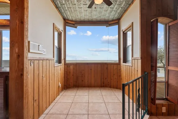 an empty room with wooden floor chandelier and glass door