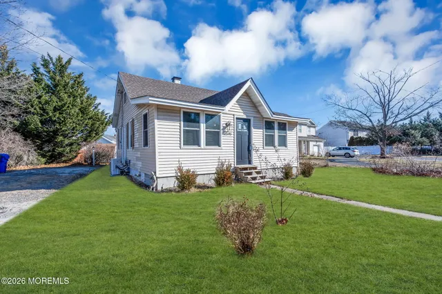 a front view of a house with a garden and trees