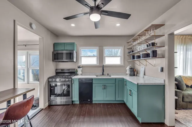 a kitchen with stainless steel appliances granite countertop a refrigerator and a stove top oven