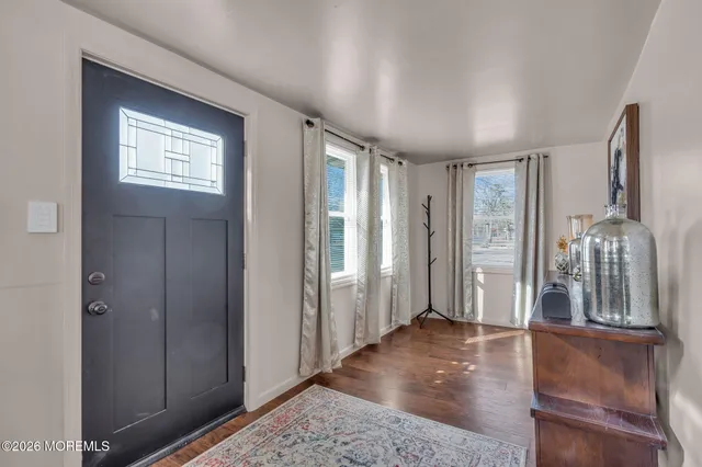 a view of a hallway with windows and chandelier