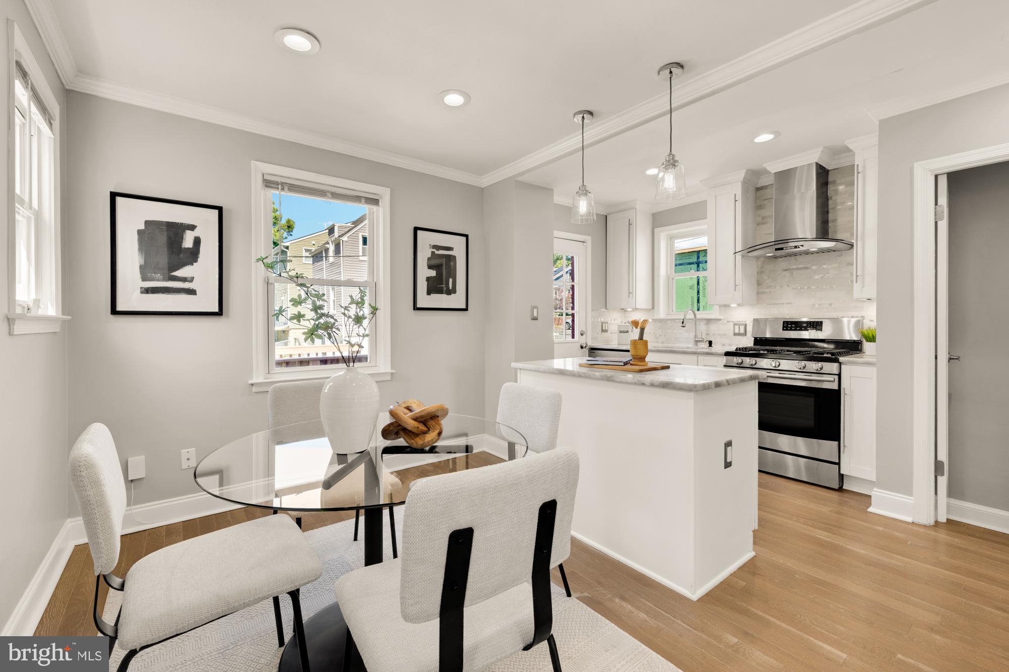 2414 Perry Street Northeast Washington, DC 20018 - Photo 13 of 49 a kitchen that has a dining table wooden floor stainless steel appliances and cabinets