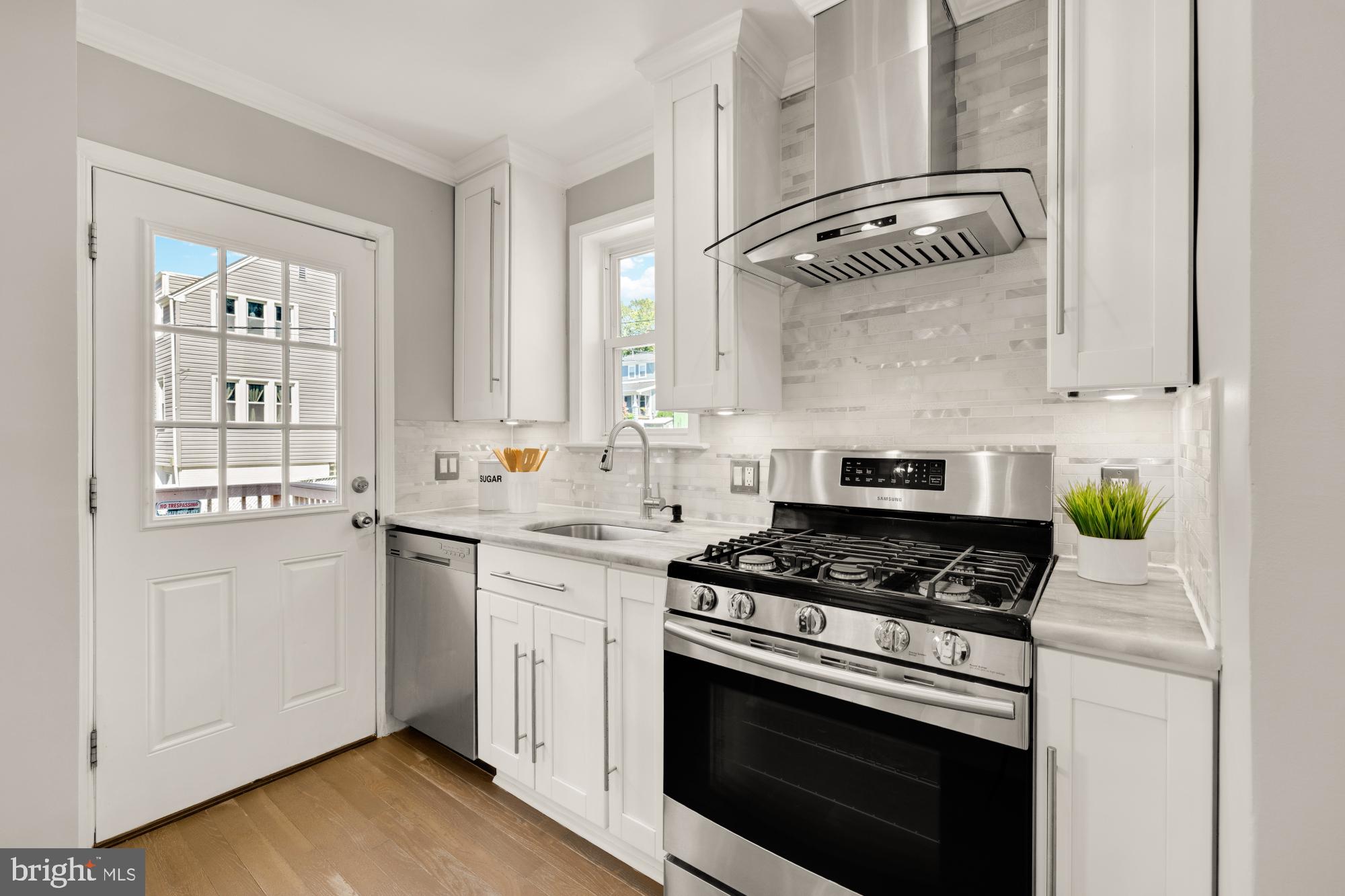 2414 Perry Street Northeast Washington, DC 20018 - Photo 17 of 49 a kitchen with cabinets appliances and a wooden floor