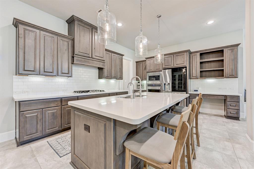 a kitchen with kitchen island a sink counter top space appliances and a center island