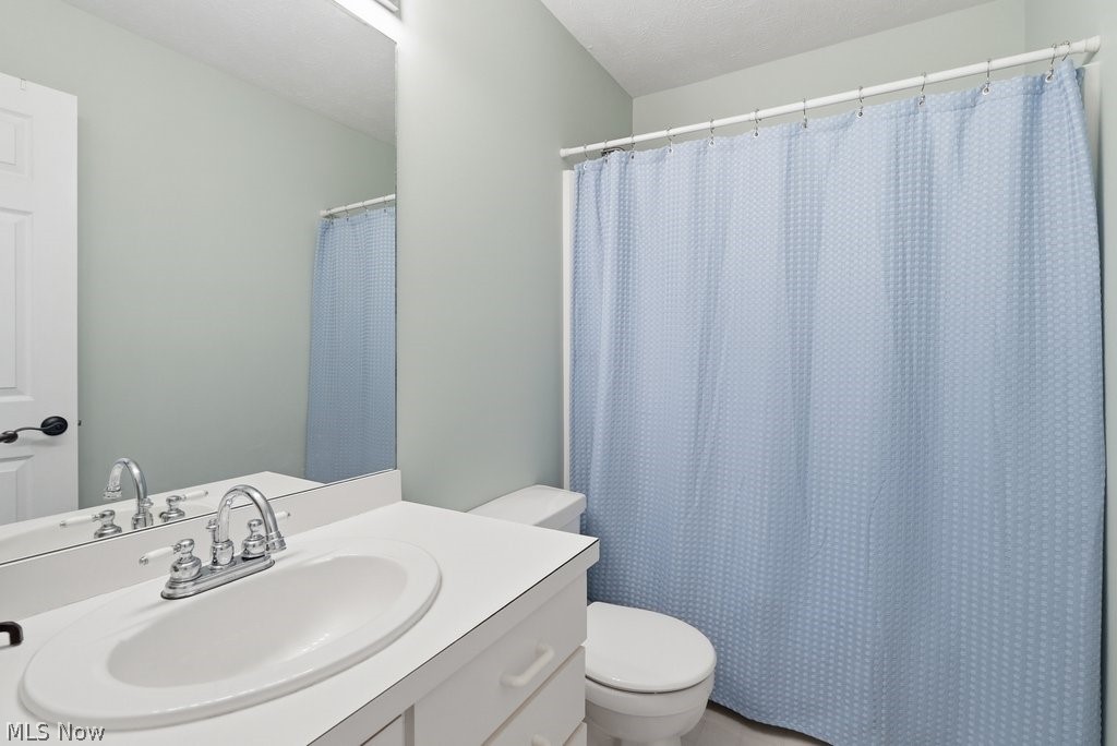 2323 Call Road Stow, OH 44224 - Photo 35 of 42 Bathroom featuring a white vanity with an integrated sink, a chrome faucet, a wall-mounted mirror, and a toilet