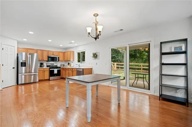 a view of a kitchen with kitchen island a large counter top space appliances and cabinets