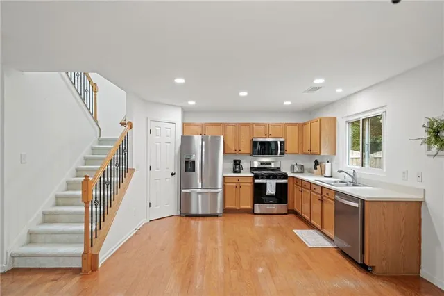 a kitchen with stainless steel appliances granite countertop a refrigerator and a stove top oven
