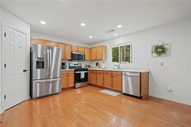 a kitchen with granite countertop a refrigerator stove top oven and sink
