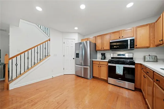 a kitchen with granite countertop a refrigerator and a stove top oven