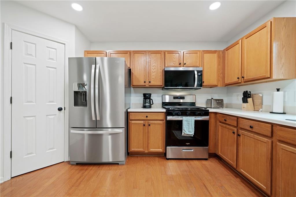 151 Nacoochee Way Canton, GA 30114 - Photo 19 of 36 a kitchen with granite countertop a refrigerator stove top oven a sink and dishwasher with wooden floor