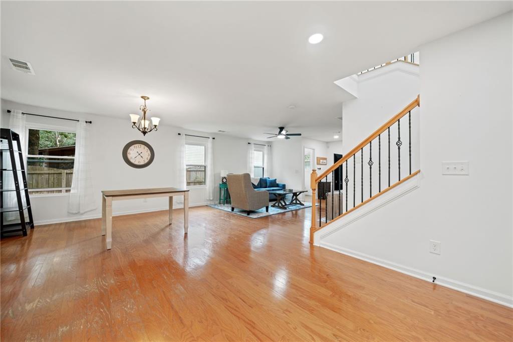 151 Nacoochee Way Canton, GA 30114 - Photo 20 of 36 a living room with couches chandelier and a dining table with wooden floor