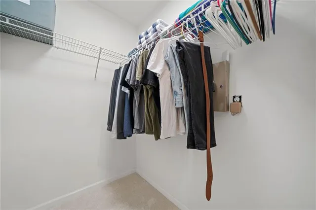 a view of walk in closet with clothes