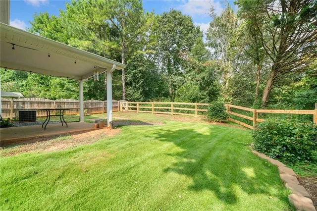 a view of a yard with a wooden fence