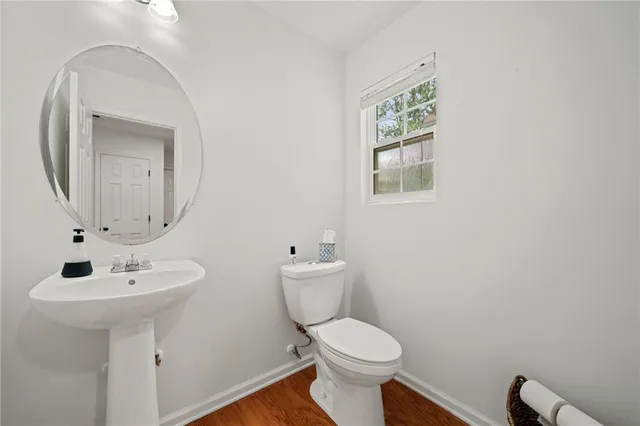 a bathroom with a toilet a sink and mirror