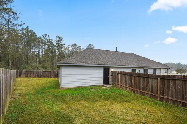 a backyard of a house with wooden floor and fence