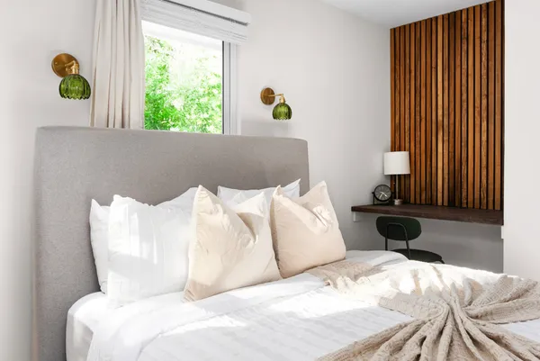 a bed sitting in a bedroom next to a window