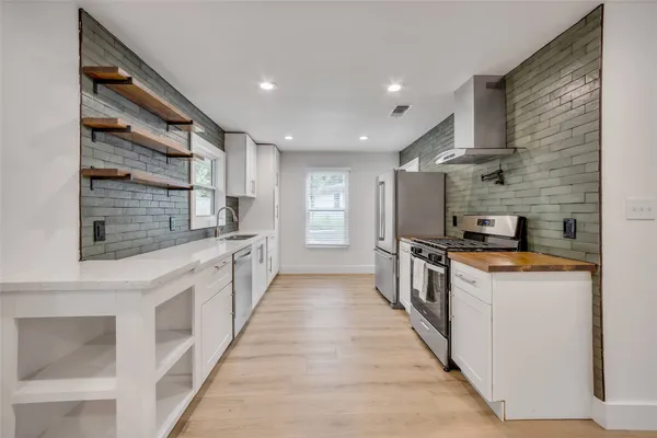 a kitchen with stainless steel appliances a sink and a refrigerator