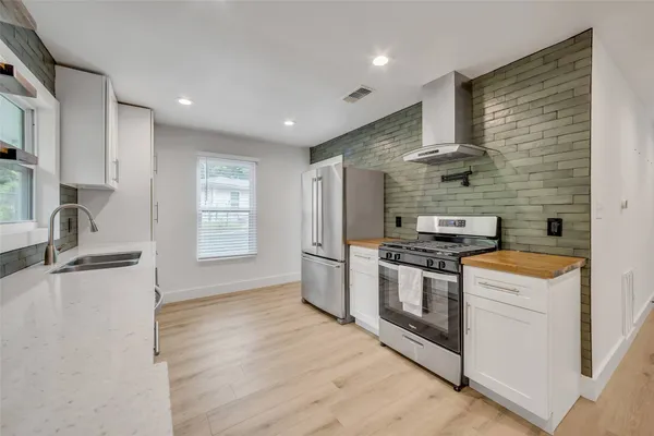 a kitchen with stainless steel appliances granite countertop a stove and a refrigerator