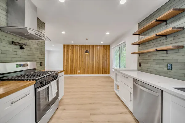 a kitchen with stainless steel appliances granite countertop a stove and a granite counter tops