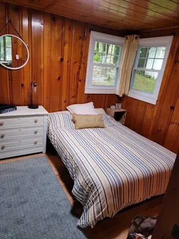 a bedroom with a bed and painting on the wall